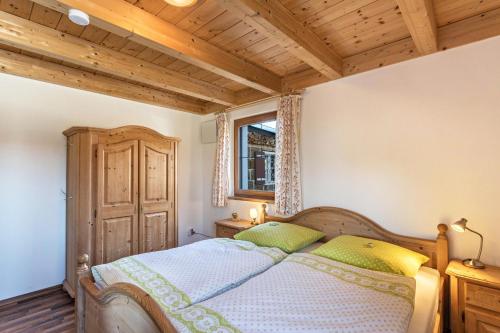 a bedroom with a bed and a wooden ceiling at Ferienwohnung Rupertiwinkl in Teisendorf