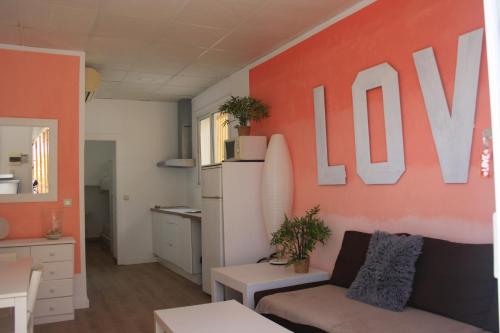 ein Wohnzimmer mit Sofa und orangefarbener Wand in der Unterkunft Love- SweethomeRooms Cabo de Palos in Cabo de Palos
