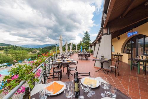 a restaurant with tables and chairs on a balcony at Glamping Florence in Troghi