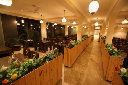 a restaurant with tables and chairs and flowers at Avenue 18 Resort in Rishīkesh
