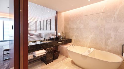 a bathroom with a large tub and a sink at InterContinental Guangzhou Exhibition Center, an IHG Hotel in Guangzhou