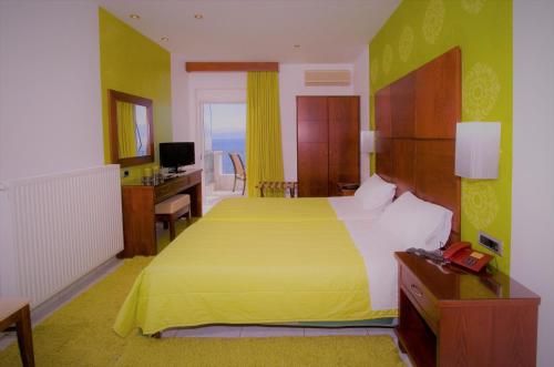 a bedroom with a bed and a desk and a television at Anemolia Studios in Loutra Edipsou