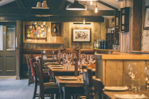 a restaurant with wooden tables and chairs with wine glasses at The Plume of Feathers in Sherborne