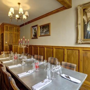 a dining room with a long table and chairs at The Plume of Feathers in Sherborne