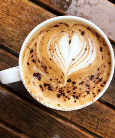a cup of coffee sitting on a wooden table at The Plume of Feathers in Sherborne