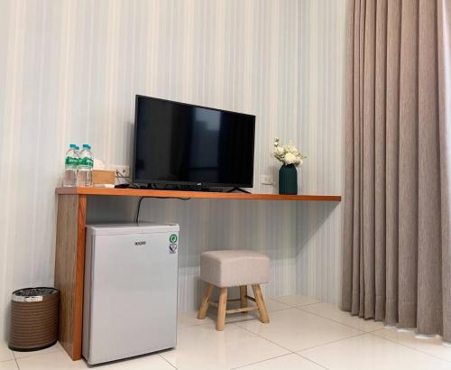 a television sitting on a desk with a chair and a tv at Forrest Cafe Villa in Jian