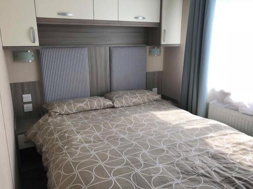 um quarto com uma cama grande e um edredão branco em Lime crescent golden sands em Mablethorpe
