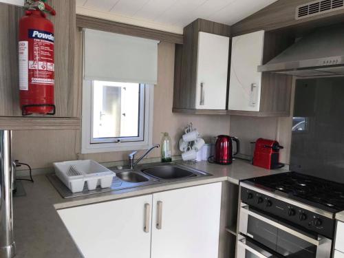 a kitchen with a sink and a stove at Lime crescent golden sands in Mablethorpe