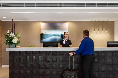 a man standing in front of a quest counter with a woman at Quest Griffith in Griffith