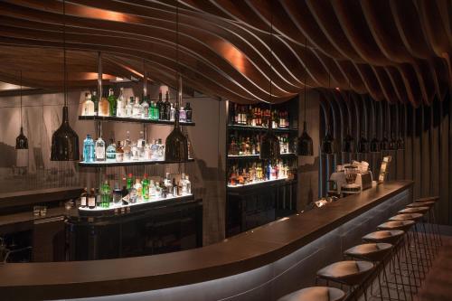 a bar with a lot of bottles of alcohol at Motel One Hamburg-Alster in Hamburg