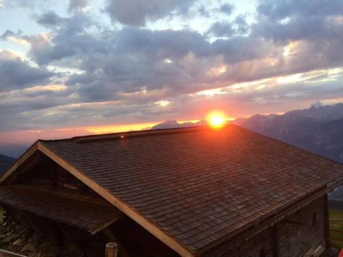 a roof of a house with the sunset in the background at Apart Grubertal in Volders