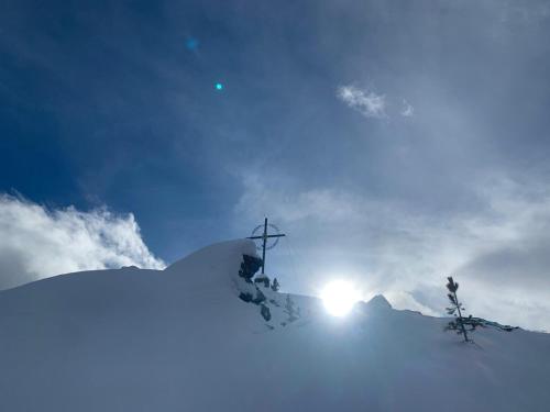 a cross on top of a snow covered mountain at Apart Grubertal in Volders