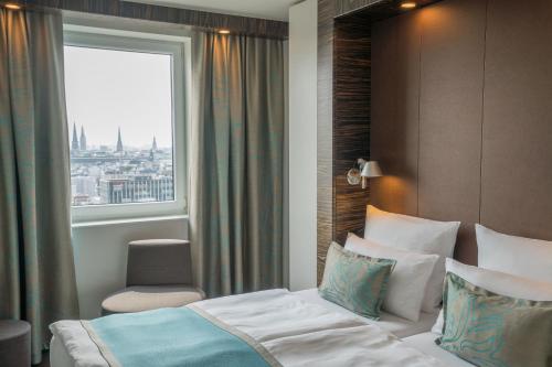 ein Hotelzimmer mit einem Bett und einem Fenster in der Unterkunft Motel One Hamburg-Alster in Hamburg