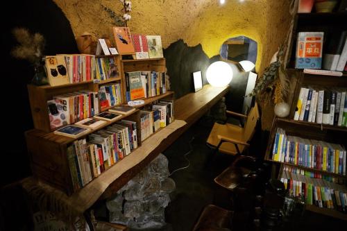 a bookstore with several shelves filled with books at Worldtreck Dinner & Guesthouse Pise in Nagano