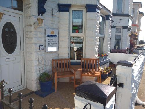 a building with two chairs and a table outside at Sandcastles Guest House in Great Yarmouth