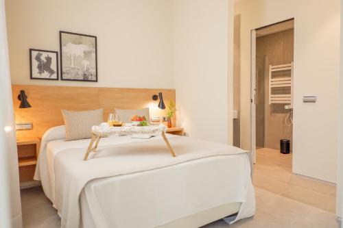 a bedroom with a bed with a table on it at U-Sense Sevilla Catedral in Seville