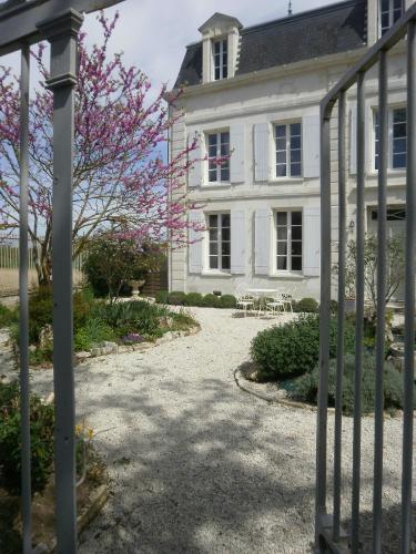 une maison blanche avec une porte en face dans l'établissement DOMAINE DE BERTHEGILLE, à Sablonceaux