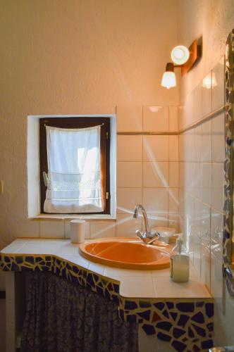 une salle de bain avec un lavabo et une fenêtre dans l'établissement La Bastide Du Claus - Vitaverde, à Cruis