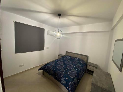 - une chambre avec un lit et un grand écran dans l'établissement Cosy apartment in Kato Paphos with pool access, à Paphos