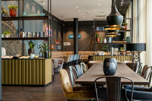 ケルンにあるモーテル ワン ケルン ワイツマルクトの木製テーブルと椅子付きのレストラン