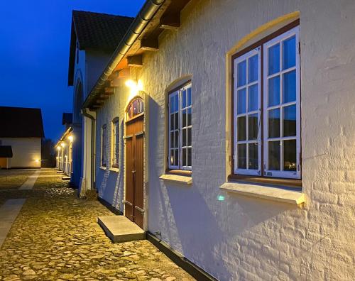 a building with windows on a street at night at Aggersvold Gods in Jyderup