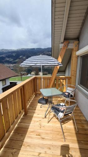 a deck with two chairs and an umbrella at Ferienwohnungen Claudia in Altossiach