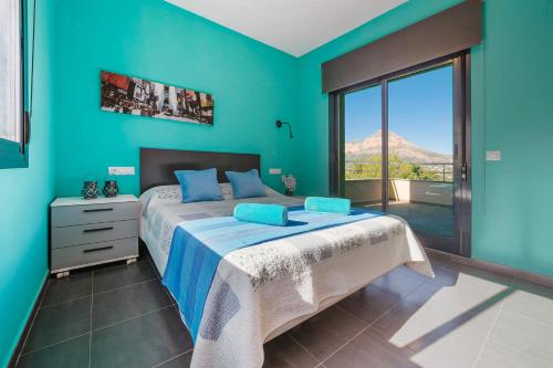 1 dormitorio con 1 cama con pared azul en 0337 Piver, en Jávea