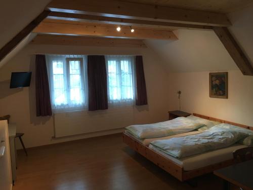 1 dormitorio con 2 camas y 2 ventanas en Hotel Löwen, en Escholzmatt
