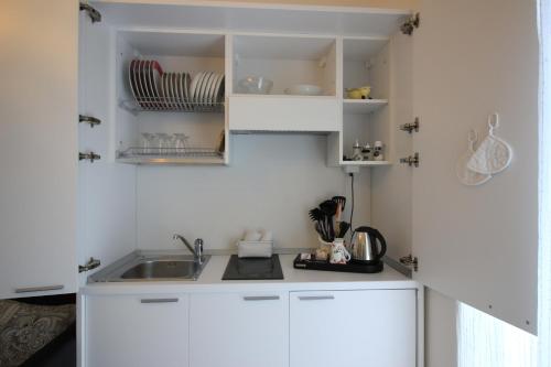 uma cozinha com armários brancos e um lavatório em Rooms Il Punto em Peschiera del Garda
