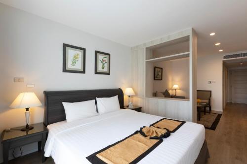a bedroom with a large white bed in a room at Kantary Bay Hotel And Serviced Apartments Sriracha in Si Racha