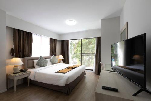 a bedroom with a large bed and a flat screen tv at Kantary Bay Hotel And Serviced Apartments Sriracha in Si Racha