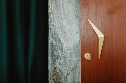 a wooden door with a handle next to a curtain at THE MODERNIST, Architecture experience in Faro