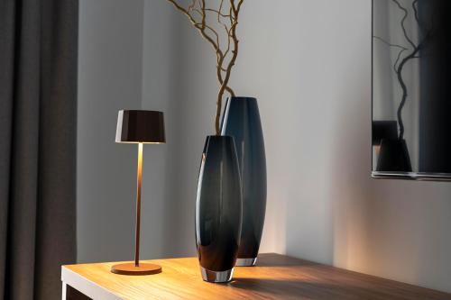a black vase sitting on a table next to a lamp at Azzurro 6 Holiday House in Martina Franca