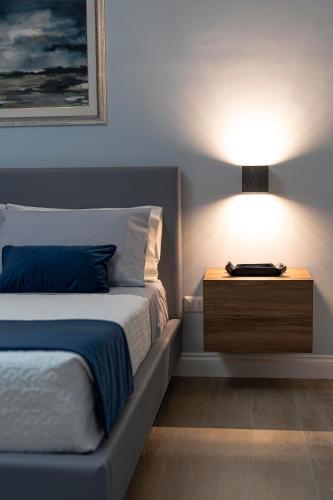 a bedroom with a bed and a nightstand with a lamp at Azzurro 6 Holiday House in Martina Franca