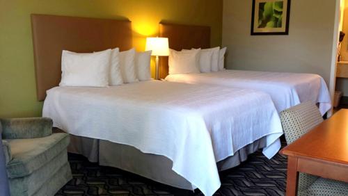 a hotel room with two beds and a chair at Wingfield Inn in Mayfield