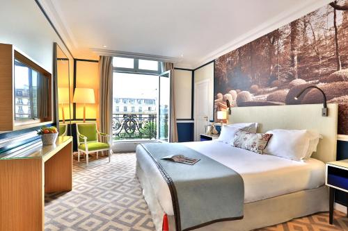 um quarto de hotel com uma cama e uma grande janela em Fraser Suites Le Claridge Champs-Elysées em Paris