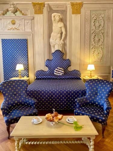 a room with a blue bed and two chairs and a table at Hotel Martelli in Florence