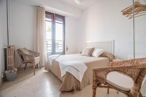 um quarto com uma cama, uma cadeira e uma janela em Rotaret em Valência