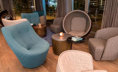 a living room with chairs and chairs and a table at Motel One München-Olympia Gate in Munich