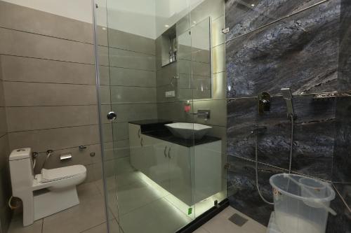 a bathroom with a toilet and a sink in a shower at The Park View Hotel in Amritsar