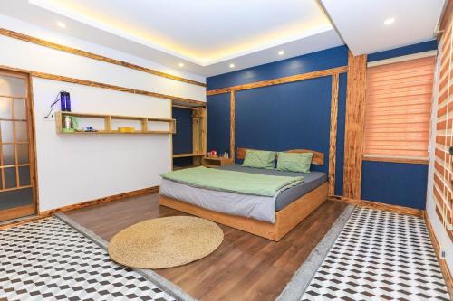 1 dormitorio con cama y pared azul en HomeStay Võ Thị Yến en Quy Nhon