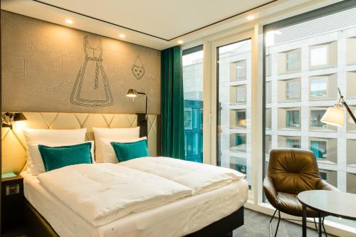 Tempat tidur dalam kamar di Motel One München-Parkstadt Schwabing