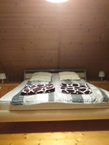 a bed with two blankets and pillows on it at Domek "U Magdy" in Sasino