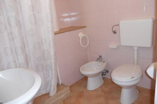 a white bathroom with a toilet and a sink at Casa Colonica in Gallipoli