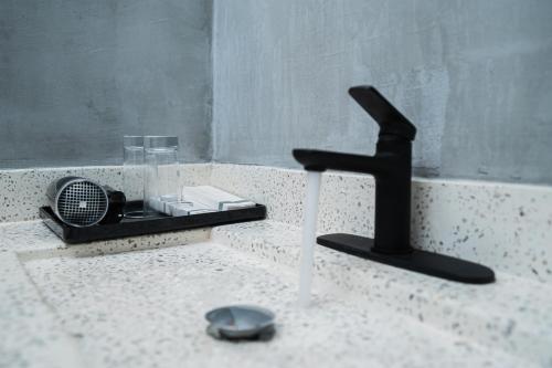 a bathroom sink with a black faucet next to a sink at Kampot Sweet Boutique in Kampot