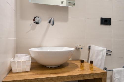a bathroom with a white bowl sink on a wooden counter at Horizon Hotel Badesi in Badesi