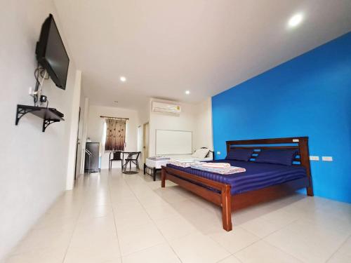 une chambre avec un lit et un mur bleu dans l'établissement Tongmai Resort, à Surat Thani