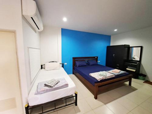 une chambre avec deux lits et un mur bleu dans l'établissement Tongmai Resort, à Surat Thani