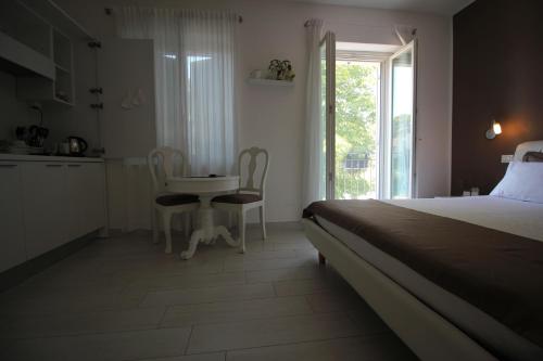 a bedroom with a bed and a table and chairs at Rooms Il Punto in Peschiera del Garda