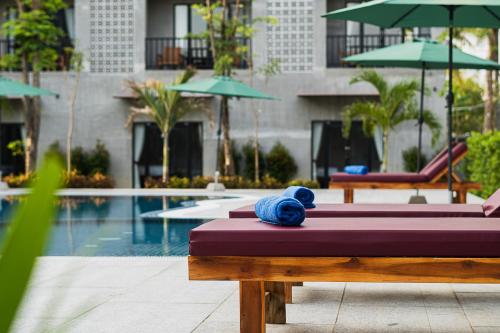a bed with blue towels on it next to a pool at Kampot Sweet Boutique in Kampot